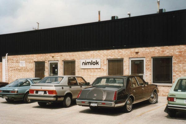 Nimlok history old building with cars parked in front